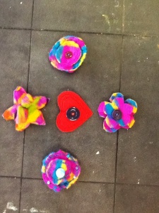 Layered felt broaches. Shaped as flowers and hearts with a button in each centre to finish it off. 