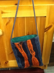 Blue and orange striped square felt bag. Green inside with blue cord strap.