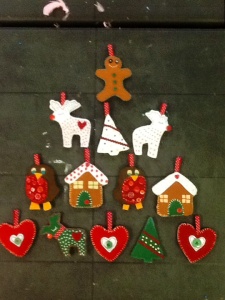 To hang on a garland. Hand sewn felt hearts, reindeers, robins, candy houses, Christmas tree  with a gingerbread man on top. Arranged like a Christmas tree shape.  