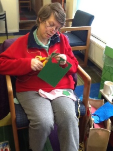 One of our ATS craft group cutting out a green felt flower shape for her pink sock.