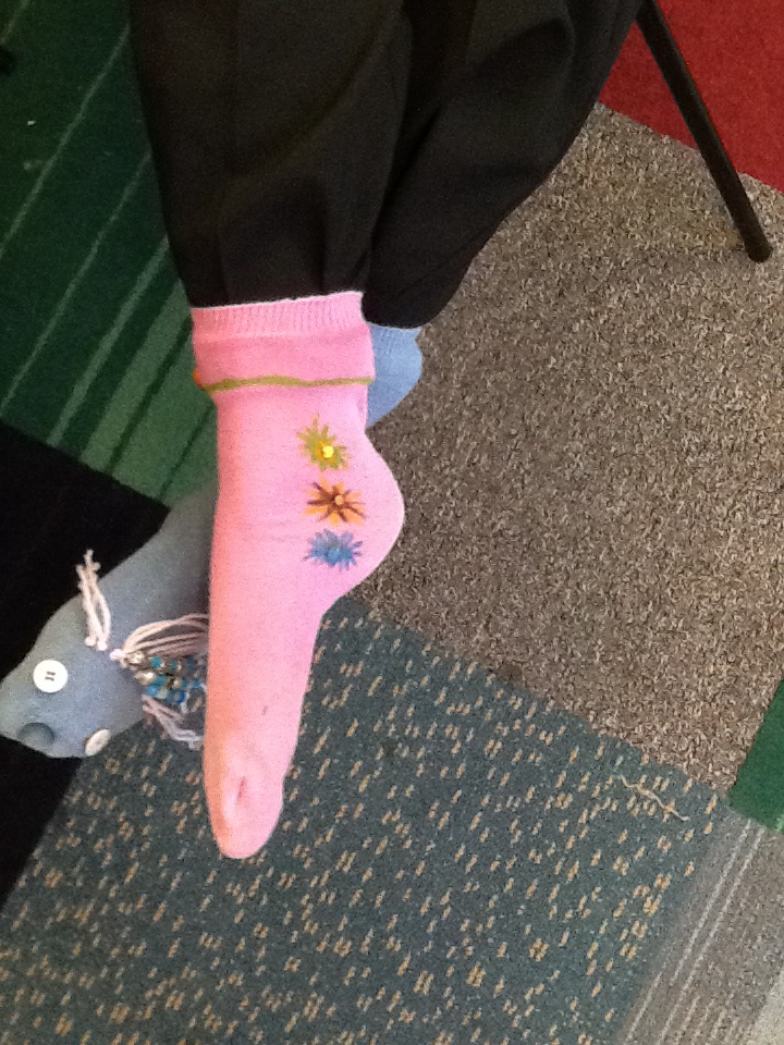 Wearing the socks. Pink tiny flowers on right foot crossed over blue sock